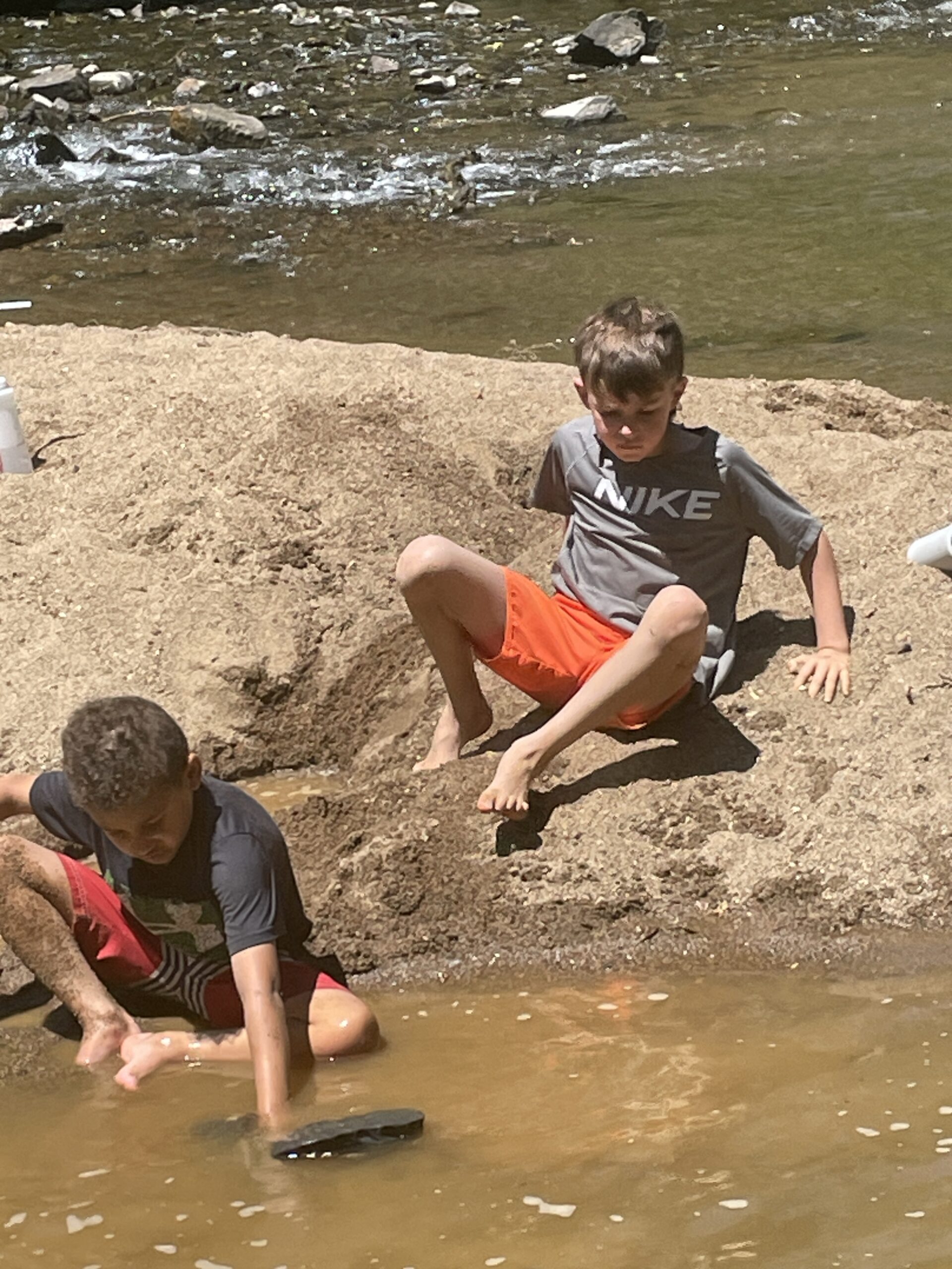 Two boys playing on all fours at the beach, practicing whole-body movement and coordination.
